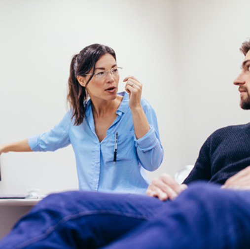 Female dentist speaking to male patient about root canal treatment